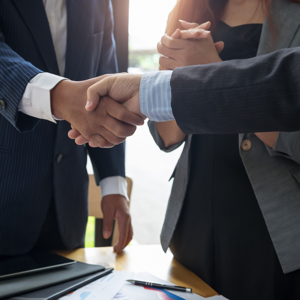 two people shaking hands as if they're completing business deal