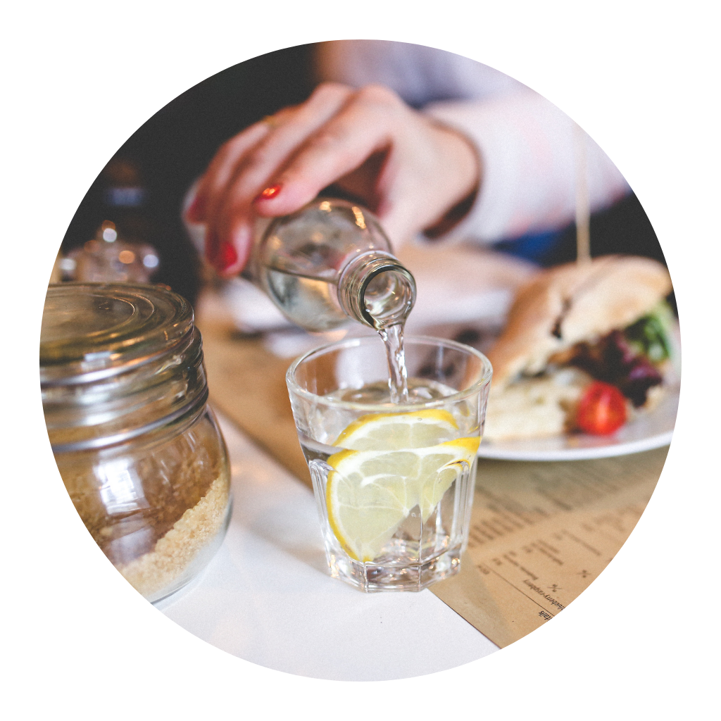 Woman pouring water into a glass at a restaurant table